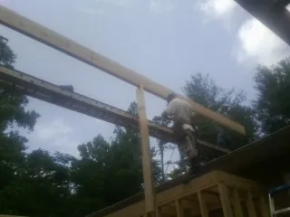 Carpenter setting a ridge beam over a new addition frame — Ice Dam Removal by Roofing Brothers in Homedale