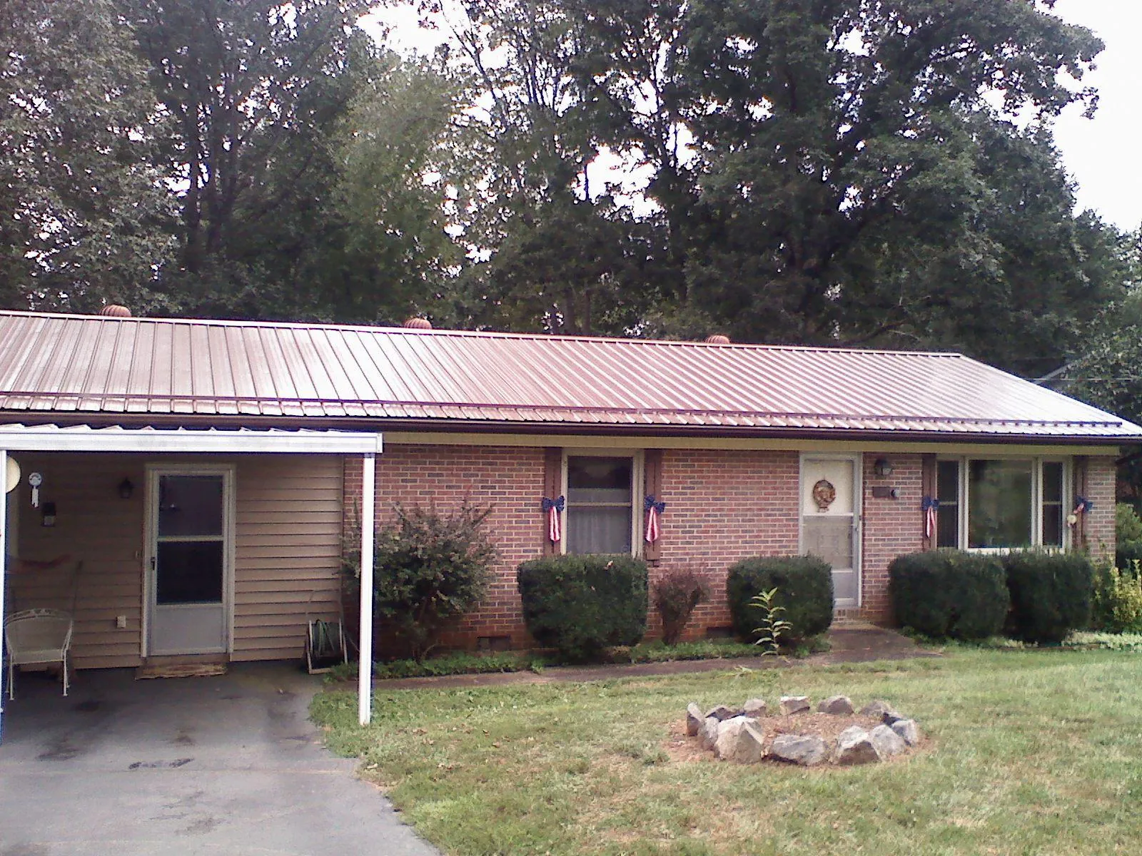 Bronze metal roof and carport on a brick ranch home — Roof Repair work by our crew in Homedale